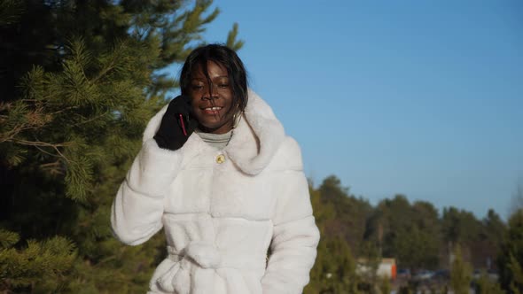 Girl with Black Skin Walks Along Forest and Talks on Phone