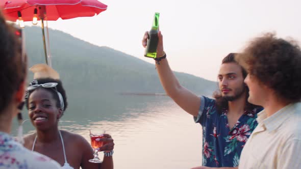 Young Friends Dancing and Toasting at Lake Party