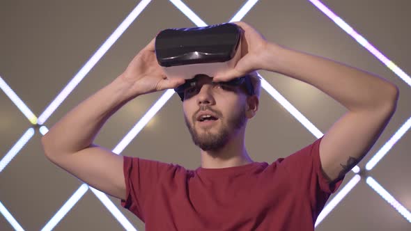 Excited Young Man Putting on 3D-googles and Making Surprised Facial Expression. Portrait of Cheerful