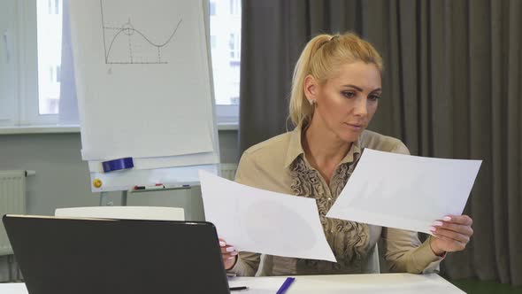 Mature Business Woman Looking Confused While Examining Documents