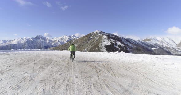 Forward Aerial Over Biker Man Cycling on Snowy Path During Winter with Mtb Ebike