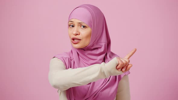 Serious Emotional Middle Aged Woman in Headscarf Saying NO and Shaking Finger in Rejection Pink