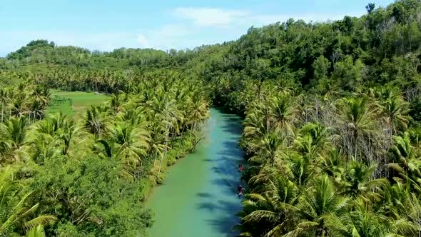 Maron river surrounded by lush vegetation, Pacitan, east Java in Indonesia. Aerial rising