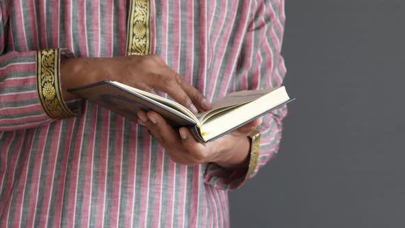 Muslim Man Hand Holding Holy Book Quran with Copy Space