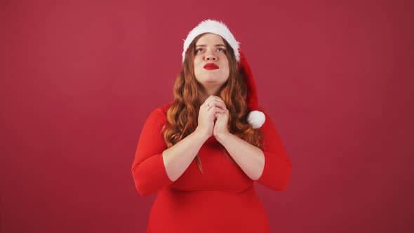 Young Plus Size Lady in Santa Hat Praying for Good Luck Asking for Cherished Wish Enjoying Dream