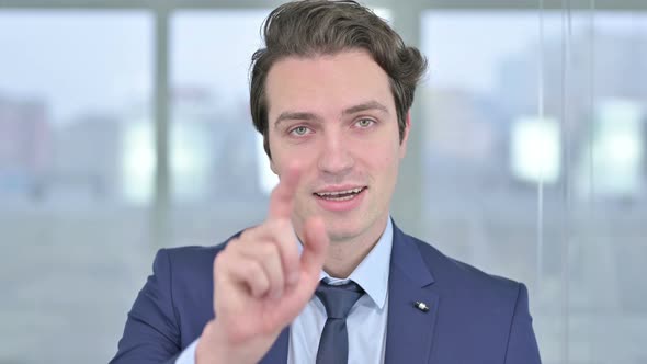 Portrait of Young Businessman Pointing Finger at Camera