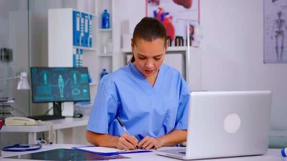 Doctor Assistant in Uniform Working on Laptop in Modern Hospital