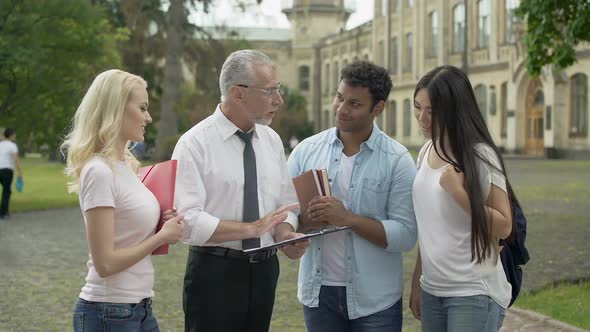 Professor Giving Assignments to Group of Multi-Ethnic Students Education