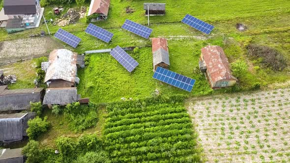 Aerial top down view of solar panels in green rural area.