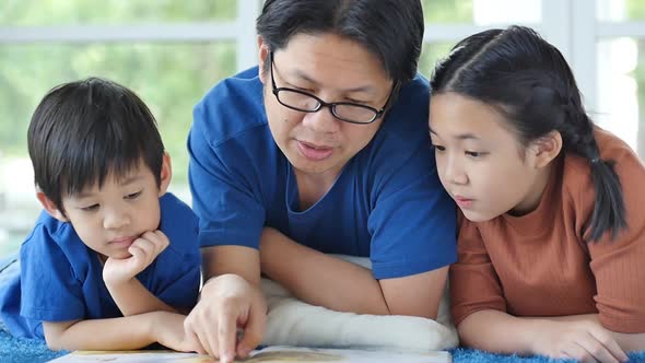 Happy Asian Family Reading Book At Home