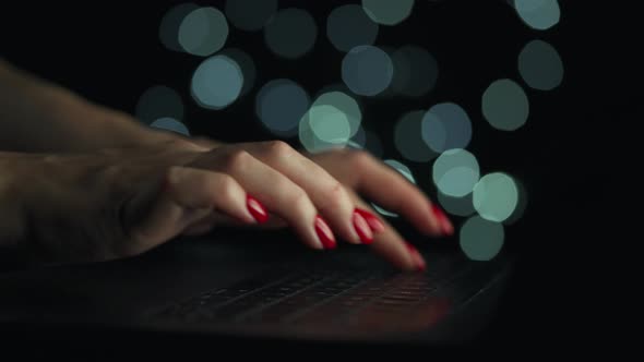 Female Hands is Typing on a Laptop at Night