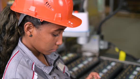 black factory worker. A young woman controls the work process in production