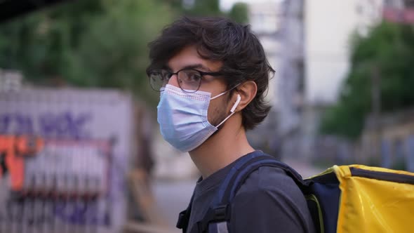 Portrait of a Delivery Man in Medical Protective Mask Side View