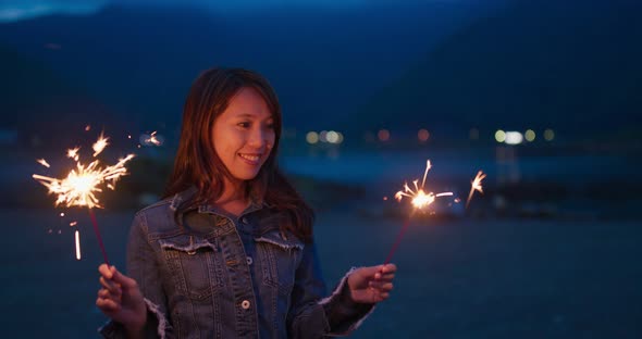 Woman play fire sparkler at outdoor