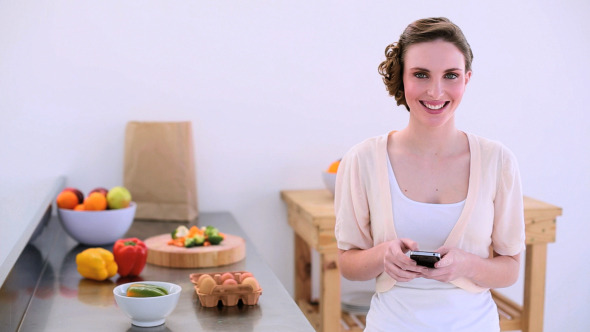 Pretty Model Standing In Kitchen Talking On Phone