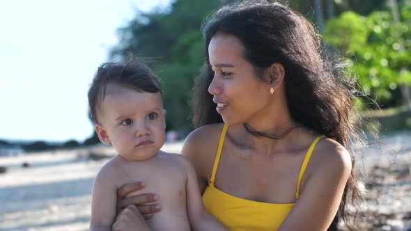 Beautiful Happy Asian Mother Lovingly Kissing Her Adorable Little Baby