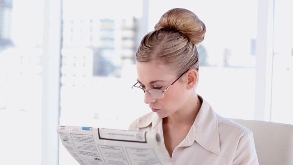 Content Blonde Businesswoman Reading Newspaper