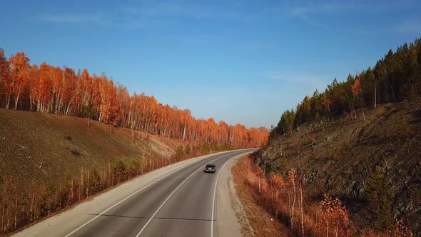 Aerial View of Car Driving on Sunny Fall Country Road Highway.