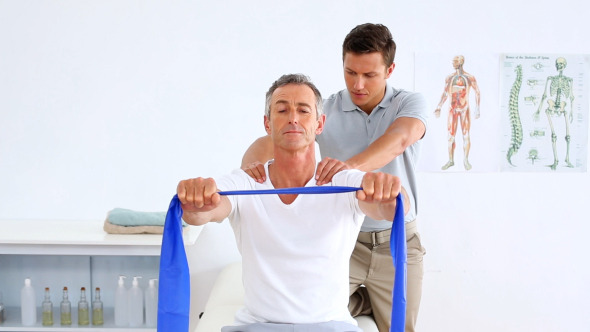 Physiotherapist Checking Mature Patient Stretching