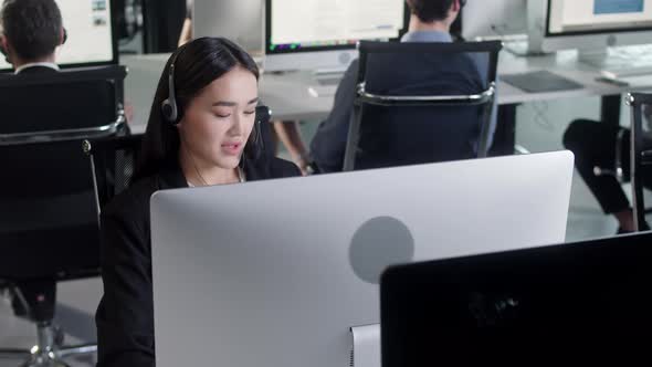 Portrait of a Technical Customer Support Specialist Talking on a Headset While Working on a Computer