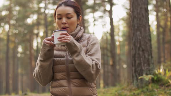 Asian Young Woman Drinking Hot Tea in Forest