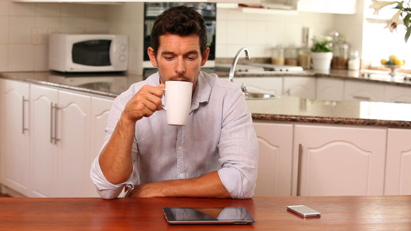 Handsome Man Using Tablet Pc At The Table