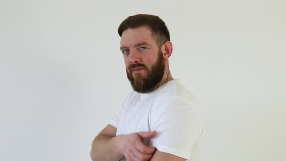 Portrait of smiling bearded man after getting a vaccine. Male holding up his white shirt sleeve