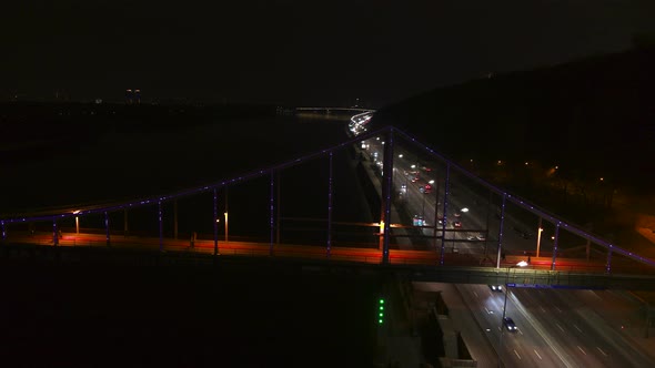 The Pedestrian Park Bridge over the Dnipro River in Kyiv City at Night Aerial View