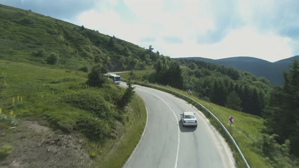 Drone Chasing Silver Sedan on Curvy Mountain Road