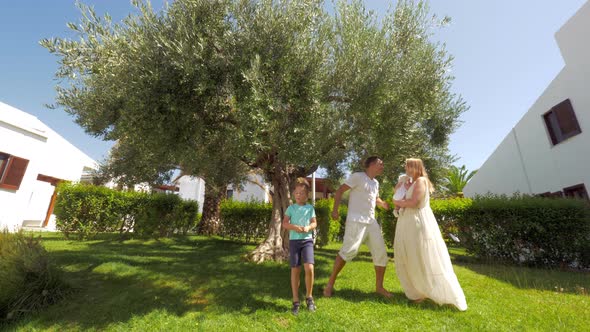 Happy parents with kids dancing in the garden