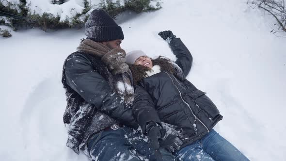Joyful Carefree Father and Daughter Falling Back on White Snow Smiling