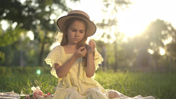 Wide Shot Thoughtful Cute Girl Sitting at Golden Sunset in Spring Summer Park