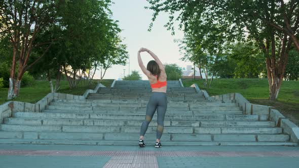 Athletic Brunette in Sportswear Doing Stretching Stone Staircase Background.