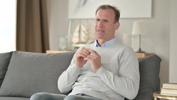 Worried Middle Aged Businessman Having Headache on Sofa