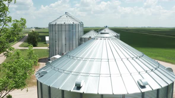 Aerial, agricultural grain bin silos on a rural farm field in the United States