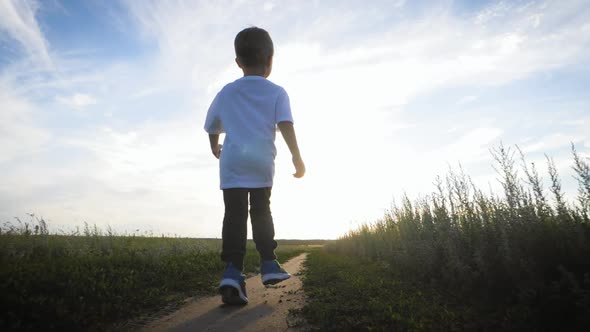 Cheerful Kid on the Road at Sunset