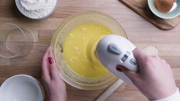 Beaten Eggs With Mixer Whisks In Bowl For Baking Carrot Cake - high angle shot