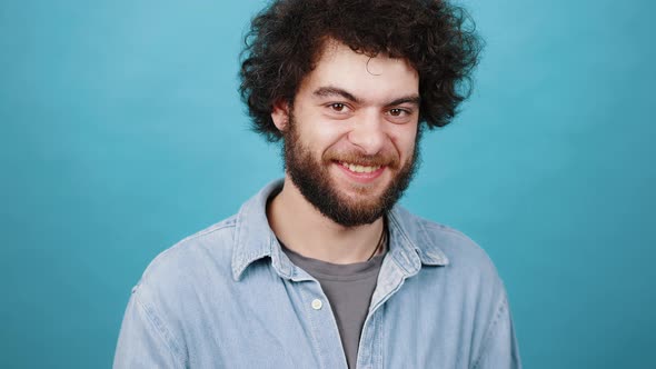 Cheerful Man with Kinky Hair Smiles Showing OK Gesture