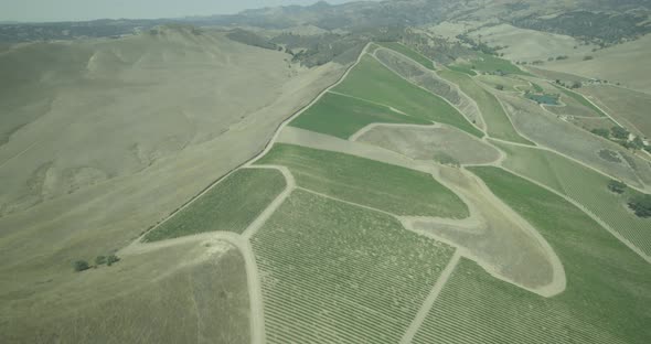 Helicopter aerial shot of green hills and valleys, overcast day