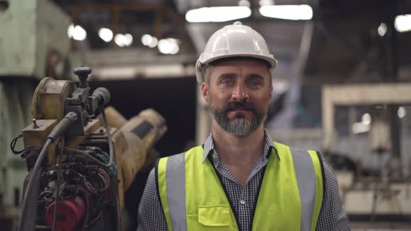 Portrait of male engineer foreman holding digital tablet looking confident at camera