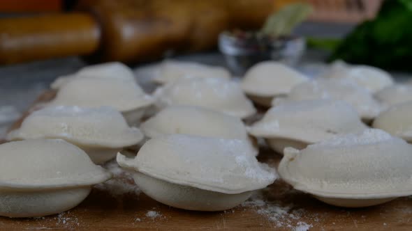 Rows of Frozen Raw Pelmeni Dumplings Stuffed with Mince Meat on Cutting Board