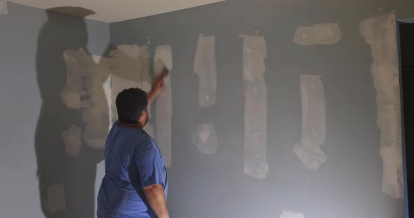 Contractor Using Sand Trowel Sanding the the Plaster Plasterboard