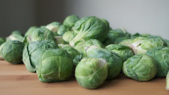 Slow Motion Push-In Shot Towards Heap of Fresh Raw Brussels Sprouts on Wooden Tabletop