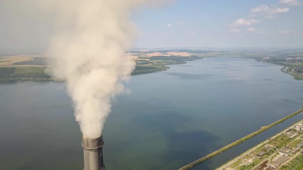 Aerial view of high chimney pipes with grey smoke from coal power plant. Production of electricity 