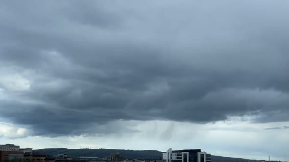 On a sunny day Dense cloud forms and then showers rain over county