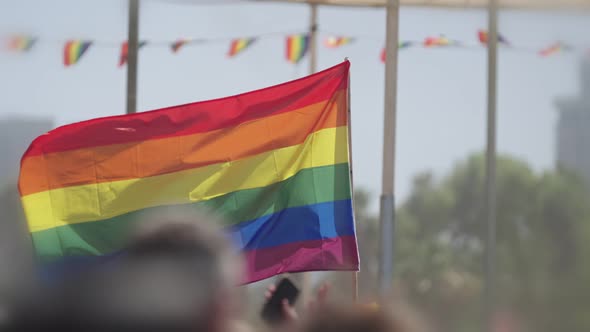 LGBTQ rainbow flag waving in slow motion during the main party in a pride parade