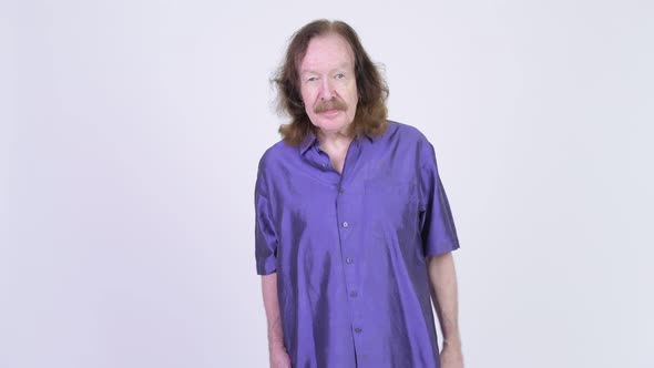 Happy Senior Man with Purple Silky Shirt Waving Hand