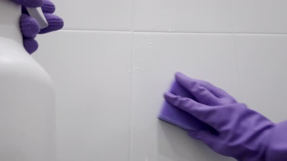 The cleaner washes the tiled wall in the bathroom. First-person view. POV