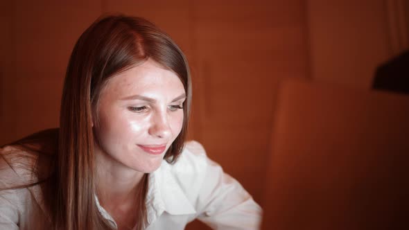 Woman Using Laptop While Lying on Bed of Hotel Room