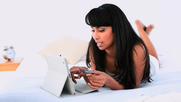 Attractive Woman Lying On Her Bed Using Her Tablet 2 alt